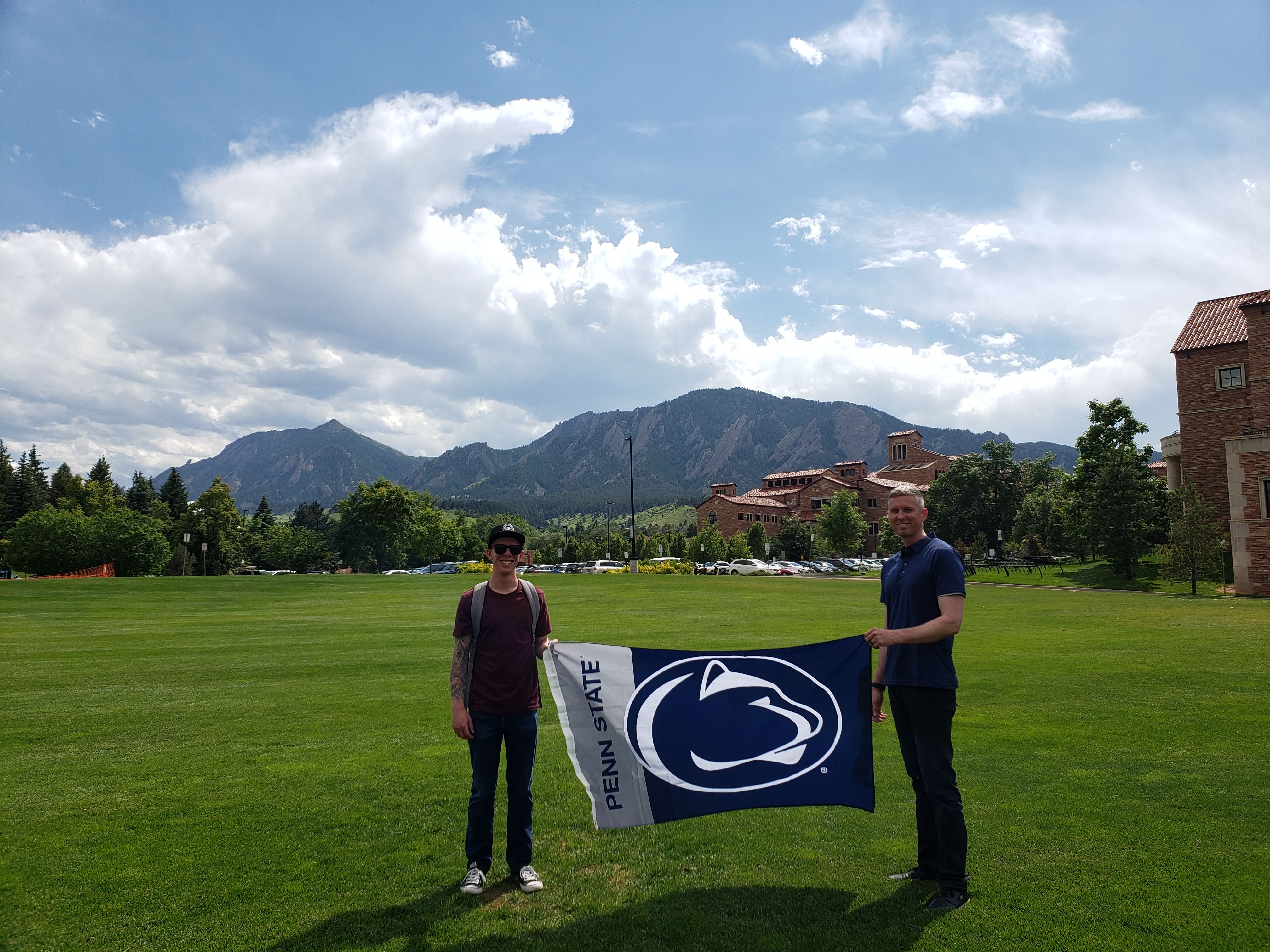 ESP students, Mason Taylor and Joshua Andresky stand on the lawn of the UC Boulder campus holding a PSU flag